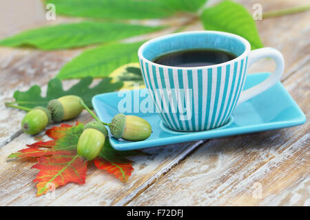 Tasse de café et les feuilles d'automne et de glands sur la surface en bois rustique Banque D'Images