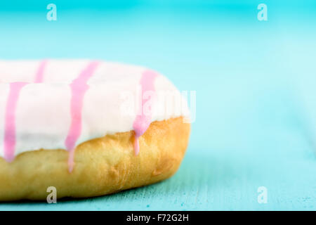 Beignet blanc et rose sur fond bleu Banque D'Images