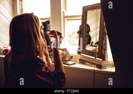 Femme constituant elle-même devant le miroir Banque D'Images