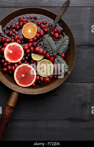 L'hiver chaud,punch sangria toddy,ou vin chaud avec du citron, pamplemousse, mandarine, citron vert et cranberry en laiton rustique de casserole Banque D'Images