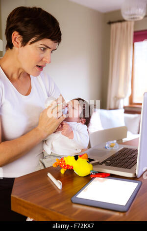 L'alimentation de la mère et son bébé à l'aide d'ordinateur portable Banque D'Images