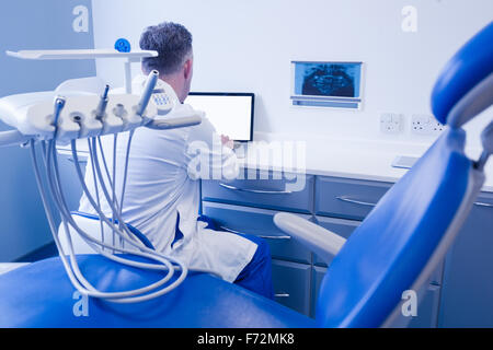 Dentiste à l'aide d'un ordinateur et de séance Banque D'Images