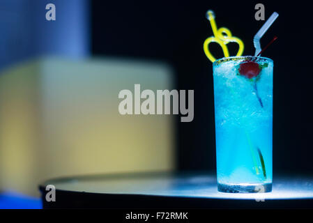 Curaçao Bleu verre à cocktail avec cerise dans la nuit dans le bar moderne Banque D'Images