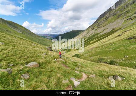 Un female hiker à marcher vers Hartsop et Brock Crags dans le Lake District, UK. Banque D'Images