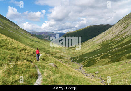Un female hiker à marcher vers Hartsop et Brock Crags dans le Lake District, UK. Banque D'Images