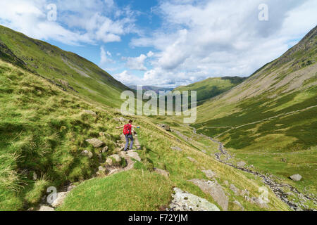 Un female hiker à marcher vers Hartsop et Brock Crags dans le Lake District, UK. Banque D'Images