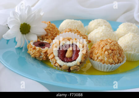 Boules de fromage farci de cerises dans les arachides et noix de coco en flocons Banque D'Images