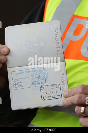 Markranstädt, Allemagne. 24 Nov, 2015. Un agent de police détient le passeport serbe d'un demandeur d'asile, qui est estampillé 'Abgeschoben'. déportés), à l'aéroport de Leipzig-Halle, à Markranstädt, Allemagne, 24 novembre 2015. PHOTO : SEBASTIAN WILLNOW/DPA/Alamy Live News Banque D'Images