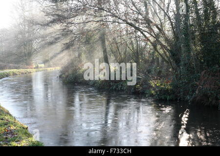 Tôt le matin, sur le canal de Brecon Monmouthshire.l'eau est gelée et la lumière du soleil filtre à travers la brume. Banque D'Images