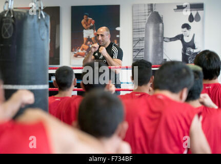 Champion du monde de boxe Arthur Abraham travaille avec les réfugiés mineurs pendant une session de formation au gymnase Max Schmeling à Berlin, Allemagne, 24 novembre 2015. L'événement avec les réfugiés non accompagnés a été organisée par Team Sauerland, fabricant d'articles de sport Adidas, la Confédération allemande de l'Artisanat et parti politique allemand CDU. Photo : SOEREN STACHE/dpa Banque D'Images