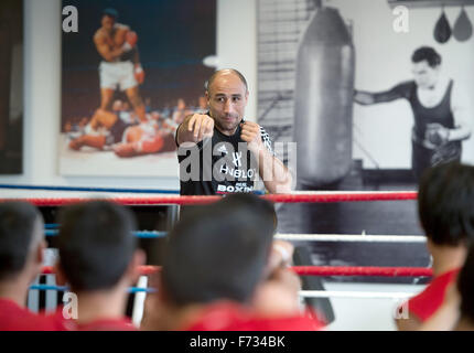 Champion du monde de boxe Arthur Abraham travaille avec les réfugiés mineurs pendant une session de formation au gymnase Max Schmeling à Berlin, Allemagne, 24 novembre 2015. L'événement avec les réfugiés non accompagnés a été organisée par Team Sauerland, fabricant d'articles de sport Adidas, la Confédération allemande de l'Artisanat et parti politique allemand CDU. Photo : SOEREN STACHE/dpa Banque D'Images