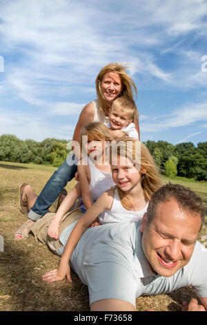 Famille avec trois enfants jouant dans un parc. Banque D'Images