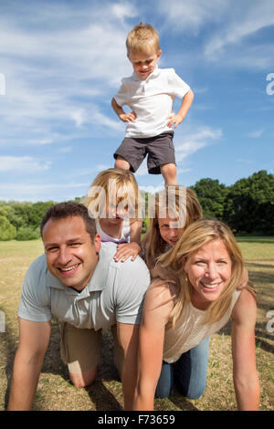 Famille avec trois enfants jouant dans un parc. Banque D'Images