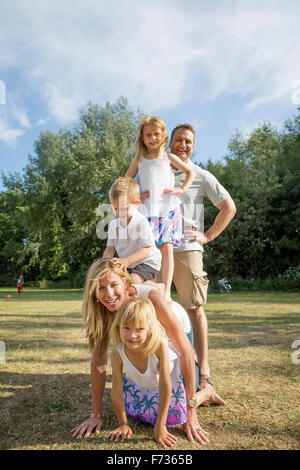 Famille avec trois enfants jouant dans un parc. Banque D'Images