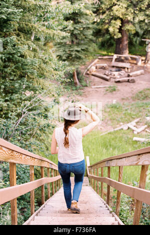 Portrait d'une femme marchant dans un escalier en bois raide. Banque D'Images