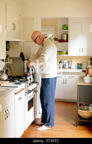 Homme debout dans une cuisine, faire du café. Banque D'Images