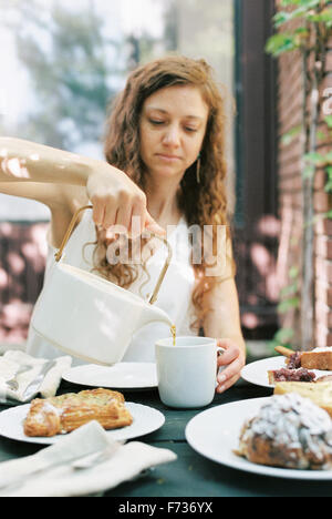 Woman pouring une tasse de thé. Banque D'Images