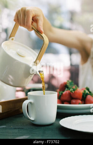 Woman pouring une tasse de thé. Banque D'Images