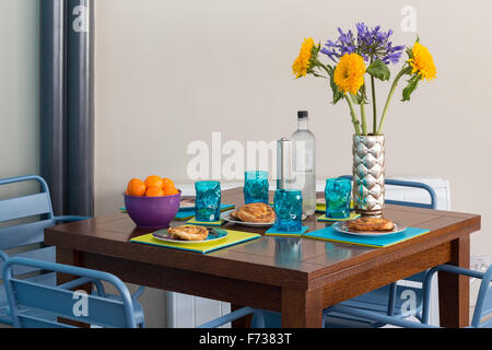Salle à manger contemporaine aux couleurs vives avec set de table pour le petit-déjeuner continental léger Banque D'Images