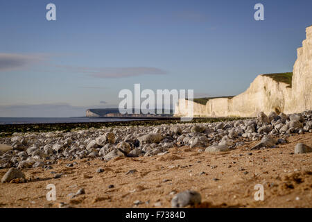 Urrugne - stones close up in focus avec sept soeurs lointain flou en arrière-plan littoral - East Sussex. Banque D'Images