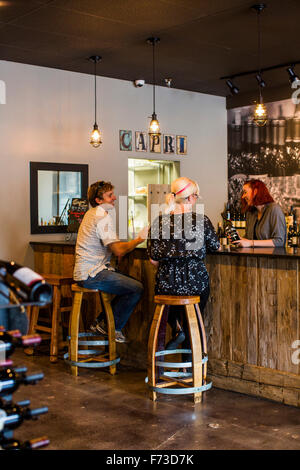 Un couple est assis au bar d'une salle de dégustation de vins et de tous les vins unique bénéficie sur le nord-ouest. Banque D'Images