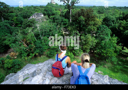 Les visiteurs se détendre au sommet de la pyramide principale, le parc national de Tikal, Guatemala. Banque D'Images