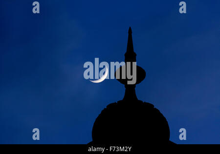 Un petit dôme et embout en haut d'un minaret sur Brighton Pavilion. Croissant de lune derrière. Banque D'Images