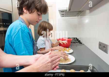 Le pétrissage de la famille pour faire panellets massepain dans la cuisine. Banque D'Images