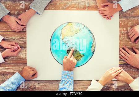Close up of hands with globe photo at table Banque D'Images