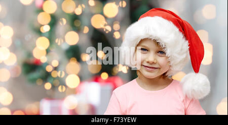 Smiling little girl in santa hat à la maison Banque D'Images