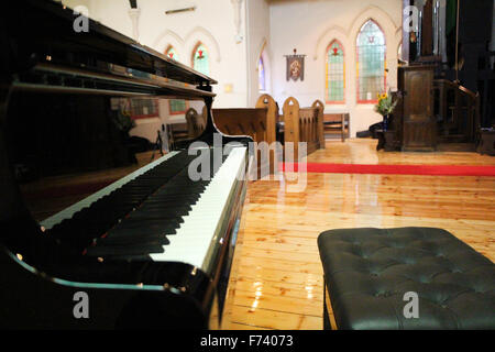 Gros plan d'un magnifique piano à queue noir dans une église Banque D'Images