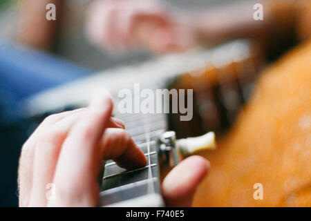 Extreme close-up de la main d'un homme joueur de banjo sur les frettes. Banque D'Images