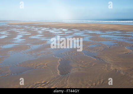 Rippled sand et de l'eau de mer sur une plage à marée basse. Scremerston, Weymouth, Dorset, Angleterre. Banque D'Images