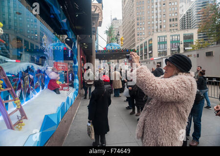 La foule des visiteurs de Macy's Herald Square à New York voir le 'A Charlie Brown Christmas'' l'affichage de la fenêtre de thème le dimanche, Novembre 22, 2015. Les quatre grandes chaînes de magasins, Macy's, JCPenney, Kohl's, Nordstrom et sont tenus de signaler qu'une moyenne de 1,2  % du chiffre d'affaires au troisième trimestre par rapport à l'estimation de 10  % pour les magasins à rabais. (© Richard B. Levine) Banque D'Images