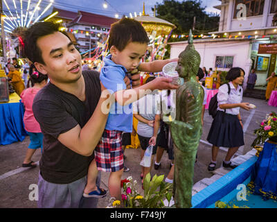 25 nov., 2015 - Bangkok, Bangkok, Thaïlande - Un homme et son fils se baigner une statue de Bouddha pendant au Wat Loy Krathong Yannawa à Bangkok. Loy Krathong a lieu le soir de la pleine lune du 12e mois dans le calendrier lunaire traditionnel thaïlandais. Dans le calendrier occidental cette tombe habituellement en novembre. Loy signifie "float", tandis que se réfère à l'krathong habituellement contenant en forme de lotus qui flotte sur l'eau. Les Krathongs illumines traditionnelles sont faites de couches du tronc d'un bananier ou un spider lily plante. Maintenant, beaucoup de gens utilisent les Krathongs illumines de pain frais qui se désintégrer dans l'eau et de fe Banque D'Images