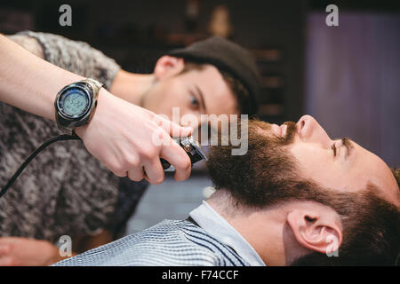 Homme barbu attrayant de se raser la barbe par coiffure moderne dans la région de barber shop Banque D'Images