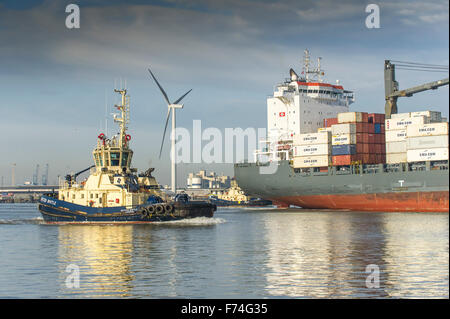 Le remorqueur, Svitzer Bootle la préparation d'escorter le conteneur cargo, Pomerenia ciel comme elle quitte le port de Tilbury sur la riv Banque D'Images