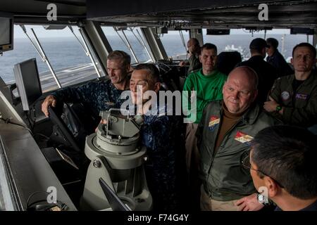 Vice-amiral de la Marine américaine Joseph Aucoin, commandant de la 7e Flotte, gauche, Vice-Adm. Yasuhiro Shigeoka, commandant en chef, le Japon, la sécurité de la flotte d'autodéfense, et arrière gauche centre Adm. John Alexander, commandant de la force de combat, 7e Flotte, droite, observer les opérations de vol depuis la passerelle de navigation de la classe Nimitz porte-avions USS Ronald Reagan lors des exercices communs 24 novembre 2015 au large des côtes du Japon. Banque D'Images