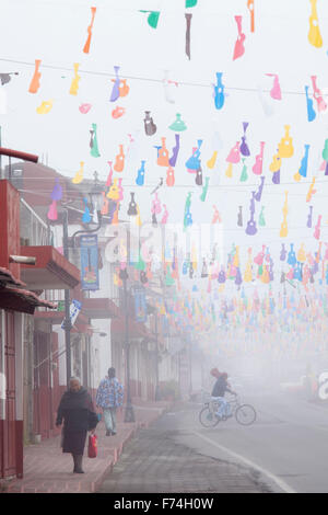 Matin brumeux dans une rue ornée de découpes de guitare Paracho, Michoacan, Mexique. Banque D'Images