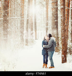 Young Couple Embracing in Winter Forest. Les vacances d'hiver. Week-end d'évasion. L'espace pour le texte. Couleurs naturelles, Selective Focus. Banque D'Images