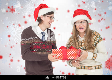 Image composite de hipster geek couple holding present Banque D'Images