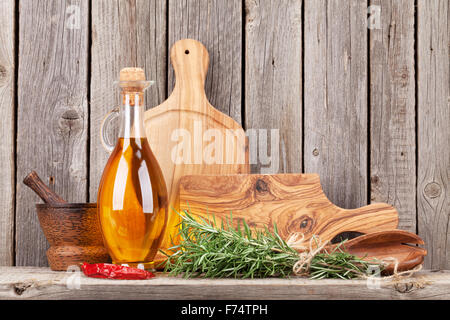 Des ustensiles de cuisine et d'épices sur une étagère contre le mur en bois rustique Banque D'Images