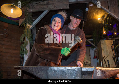 Regensburg, Allemagne. 25Th Nov, 2015. Gloria, princesse de Tour et Taxis, travaille sur un morceau de fer à l'étal d'un forgeron à la romantique Marché de Noël à St Emmeram Palace, également connu sous le nom de palais Thurn et Taxis, à Regensburg, Allemagne, 25 novembre 2015. Le marché de Noël sera ouvert jusqu'au 23 décembre 2015. Photo : ARMIN WEIGEL/dpa/Alamy Live News Banque D'Images