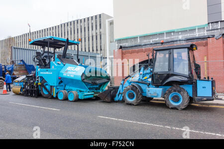 Une machine pavior un chargeur avant et un rouleau Bomag matériel pour la pose d'une aire de travail de resurfaçage des routes Banque D'Images