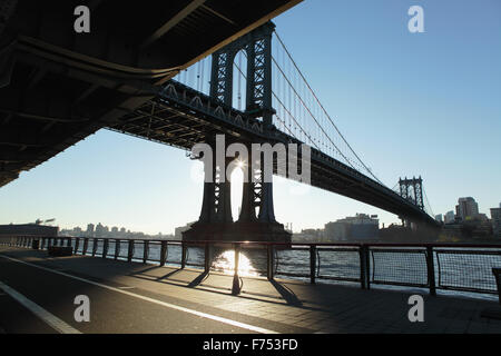 Le soleil se lève sur Brooklyn et jette des ombres profondes sur l'Esplanade de la rivière East, New York, sous le viaduc de Roosevelt Banque D'Images