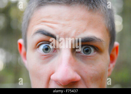 Teenage boy with regard clair en close-up en forêt. Banque D'Images