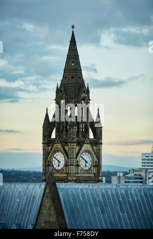 Manchester skyline montrant les toits et la tour de l'horloge de la tour de ville de l'arbre de lumière rayons à travers les nuages crépuscule aube Banque D'Images