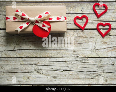 Boîte cadeau saint valentin coeur rouge et les formes, sur planche de bois Banque D'Images