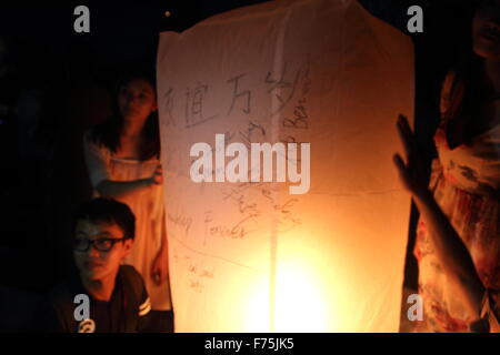 Chiang Mai, Thaïlande. 25 novembre 2015. Les touristes se rassemblent pour libérer Khom LDI (sky lantern) au cours de l'Yi Peng Festival à l'extérieur de l'Dhutanka Lanna temple à Chiang Mai. Le Kathina Lanna cérémonie se déroule autour de la Loy Krathong festival chaque année. Banque D'Images