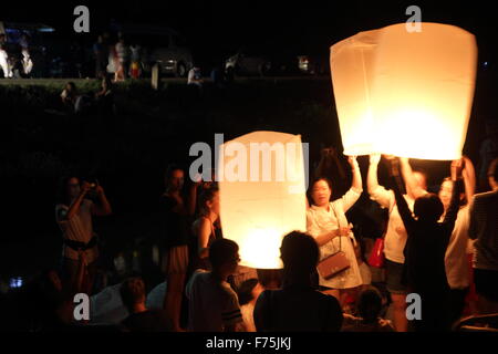 Chiang Mai, Thaïlande. 25 novembre 2015. Les touristes se rassemblent pour libérer Khom LDI (sky lantern) au cours de l'Yi Peng Festival à l'extérieur de l'Dhutanka Lanna temple à Chiang Mai. Le Kathina Lanna cérémonie se déroule autour de la Loy Krathong festival chaque année. Banque D'Images